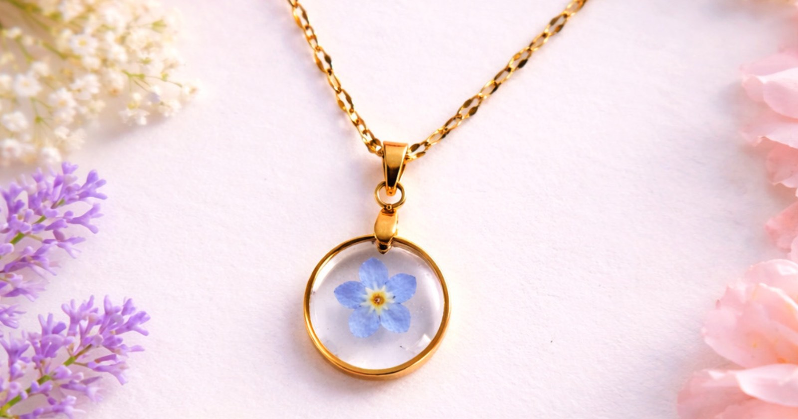 Subtelny, ręcznie wykonany naszyjnik, w którym prawdziwa niezapominajka została na stałe zatopiona w krystalicznie przejrzystej żywicy. Delikatny, jasnoniebieski kwiat pięknie kontrastuje z minimalistyczną, złoconą oprawą, tworząc elegancką i bardzo kobiecą kompozycję.