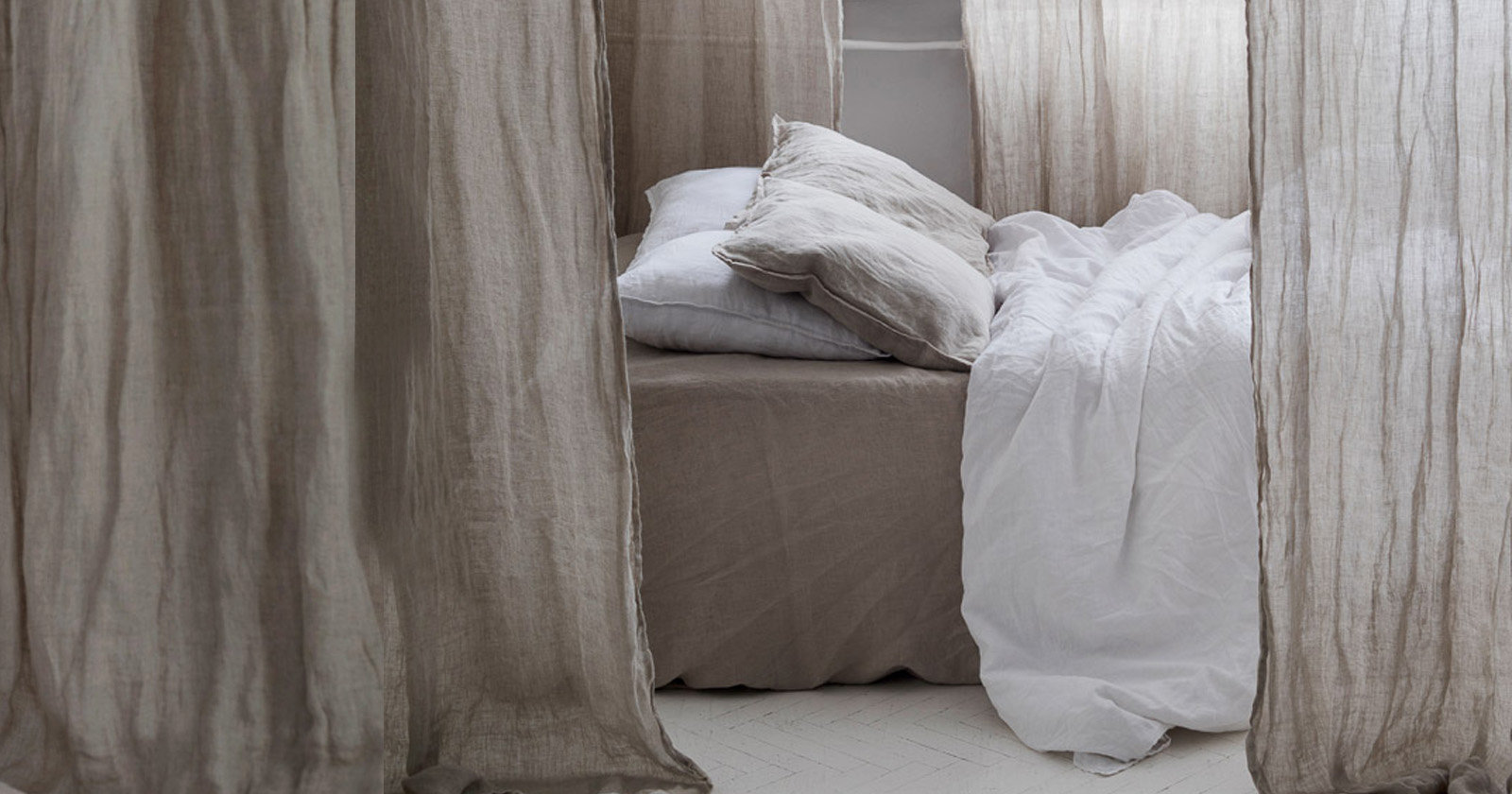 łóżko otoczone zasłonami w boho kolorze z naturalnego muślinu