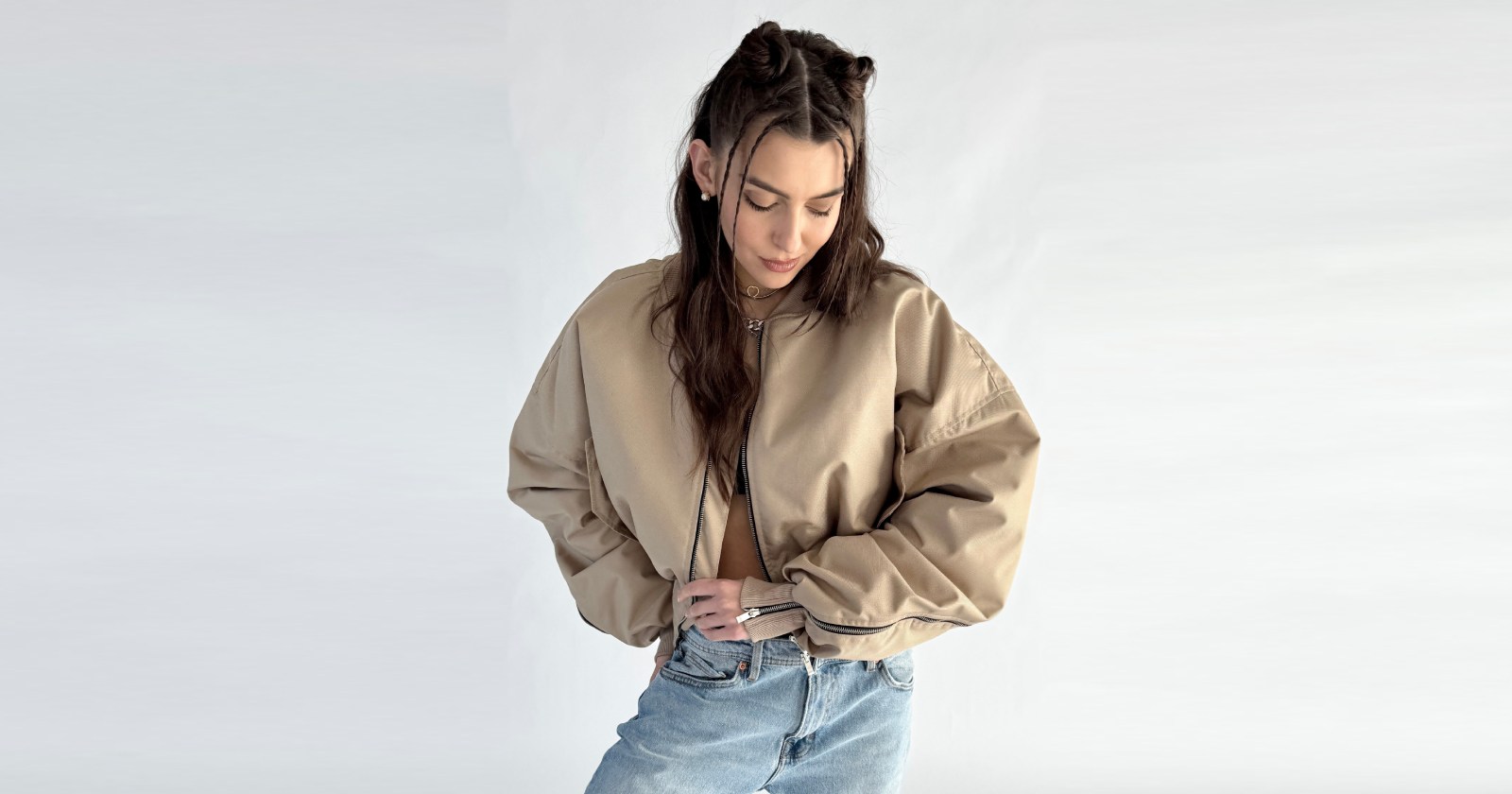 Oversiz'owa kurtka typu bomber w krótkiej wersji "short" wykonana z przeciwdeszczowej tkaniny w kolorze mocca, zapinana na metalowy zamek z charakterystyczną czarną patką