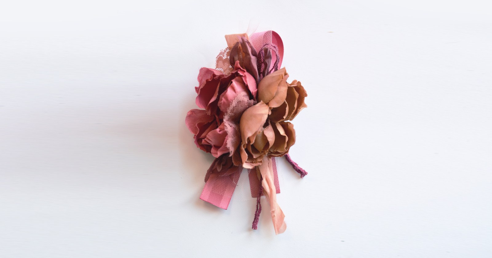 Unikatowa broszka z jedwabnymi kwiatami z kolorze beżowo-brzoskwiniowym z lekką nutką zgaszonego różu. Jedwabne kwiaty są ręcznie malowane, wycinane i formowane, ozdobione elementami z wysokiej jakości tkanin.