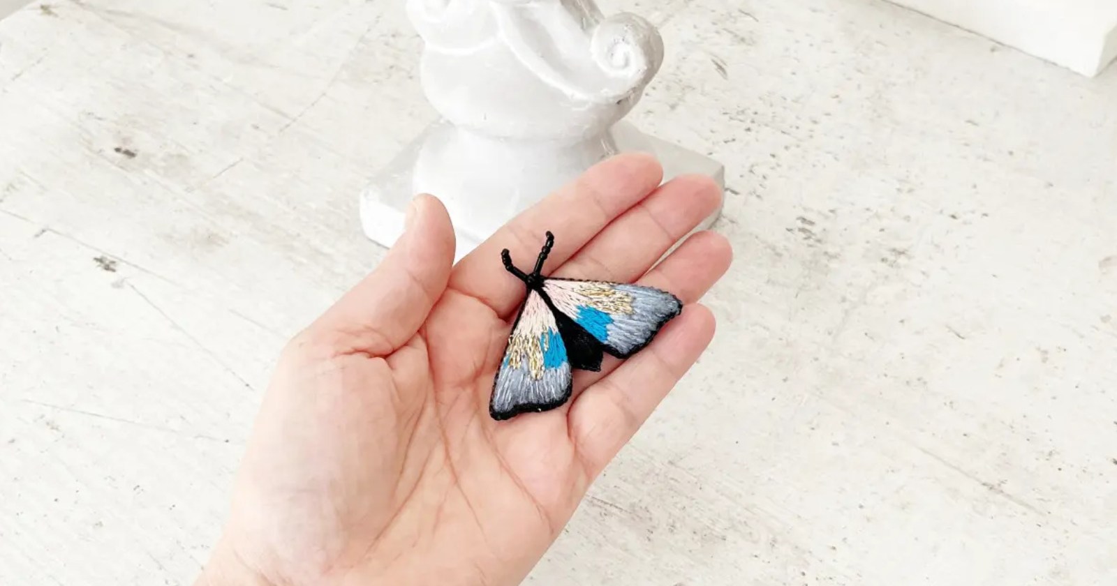 Ręcznie haftowana broszka z serii ĆMY. Każdy detal tej broszki został wykonany z największą precyzją i starannością, aby stworzyć unikalny wzór, który przyciąga uwagę