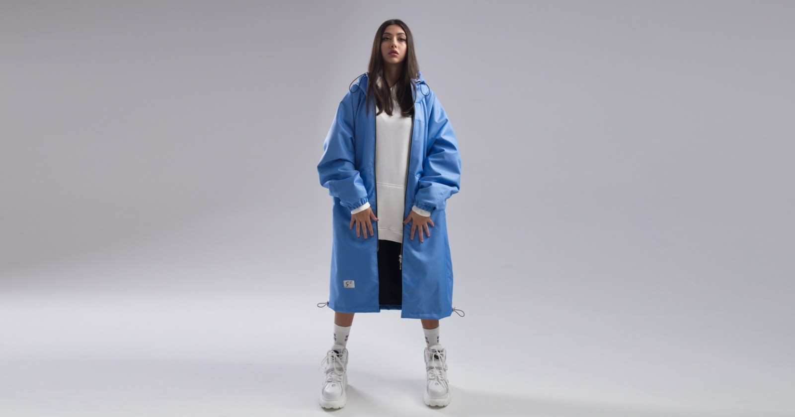 Płaszcz hoodie oversize, uszyty z przeciwdeszczowej tkaniny w kolorze baby blue niebieski podszyty lekką, czarną podszewką