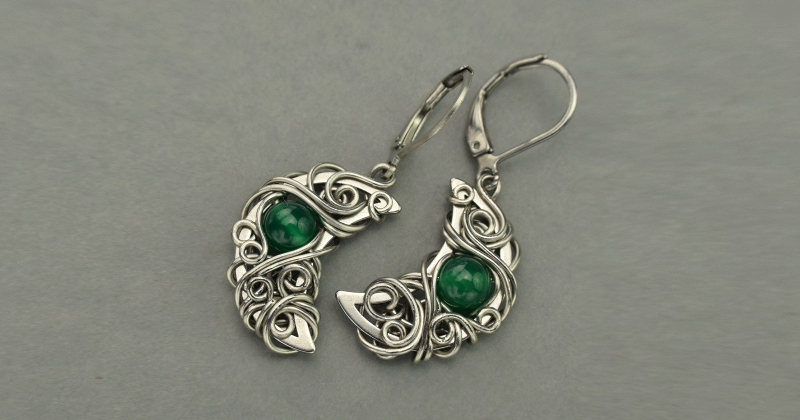 Niezwykłe, oryginalne kolczyki księżyce z zielonymi onyksami. Wykonane z drutów ze stali chirurgicznej techniką wire wrapping. Kamienie są naturalne